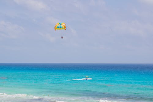 People Parachuting on Sea Shore
