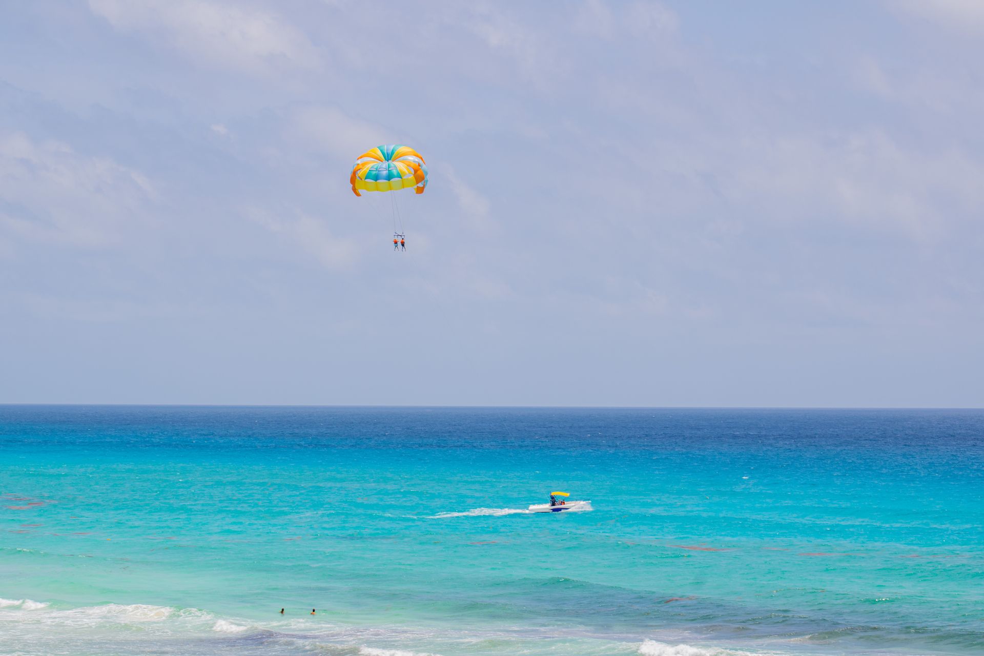Experience thrilling parasailing above the turquoise sea in Cancún, México. Perfect vacation escape.