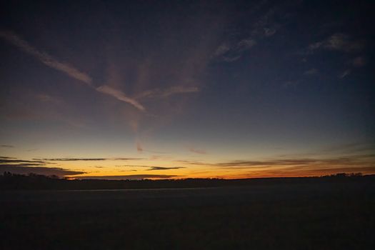 Stunning twilight sky over a grass field in Minnesota, showcasing vibrant colors.