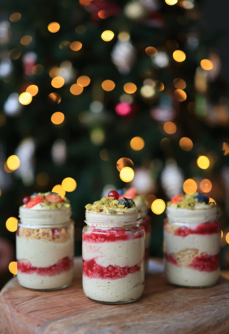 Desserts In Glass Jars On Wooden Board