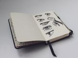 Open sketchbook with pen studies, by ckeletn on Pexels