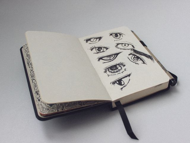 Sketchbook open to a page of ink eye studies, photo by ckeletn on Pexels