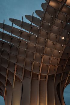 Low angle shot of a modern architectural structure with dramatic lighting against an overcast sky.