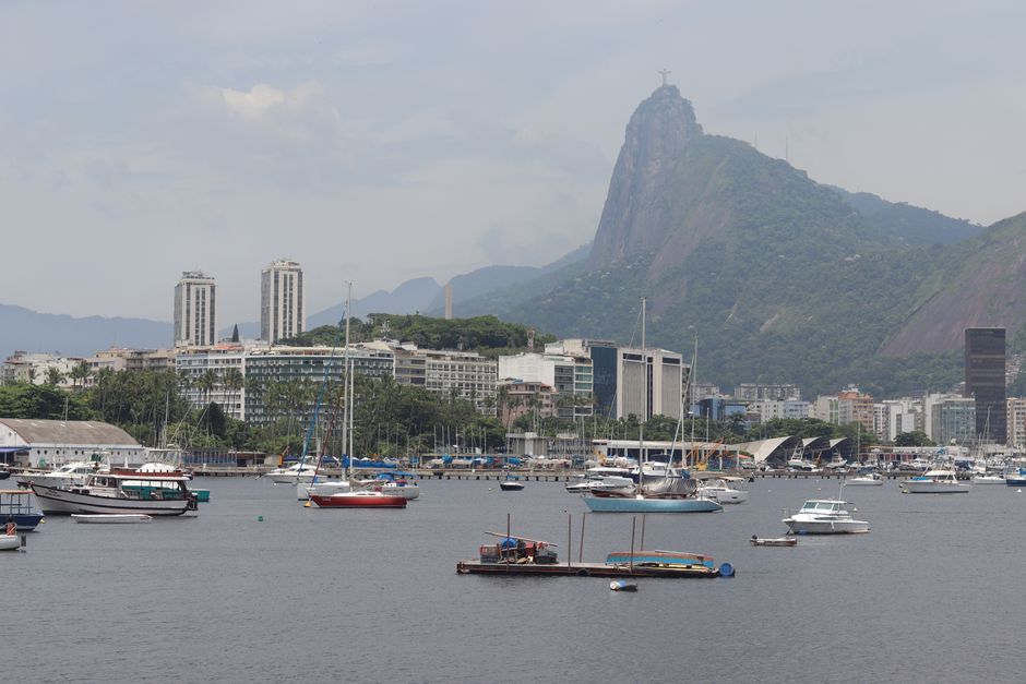 Explore the breathtaking view of Rio de Janeiro's coast with Sugarloaf Mountain in the backdrop and several sailboats docked.