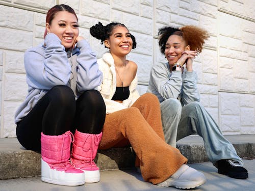 Free Smiling Teenage Girls Sitting on Pavement Stock Photo