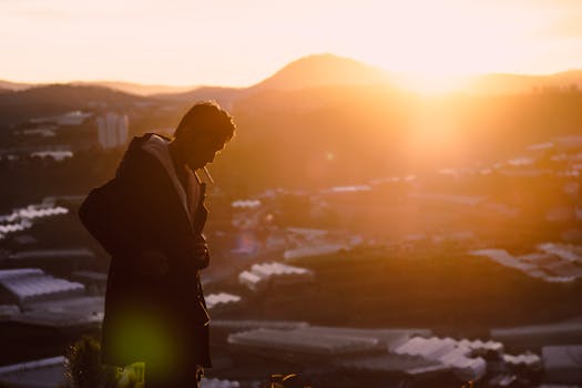 在越南多山的宁静日落映衬下，一个男人在吸烟