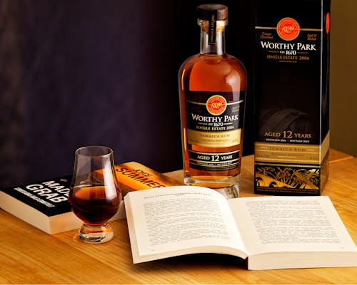 A Bottle of Whisky and a Book on a Wooden Table 