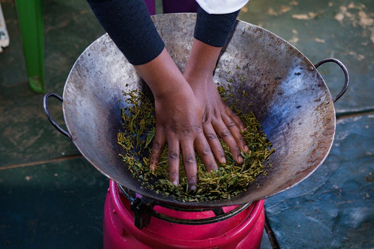 A Person Cooking In A Wok 