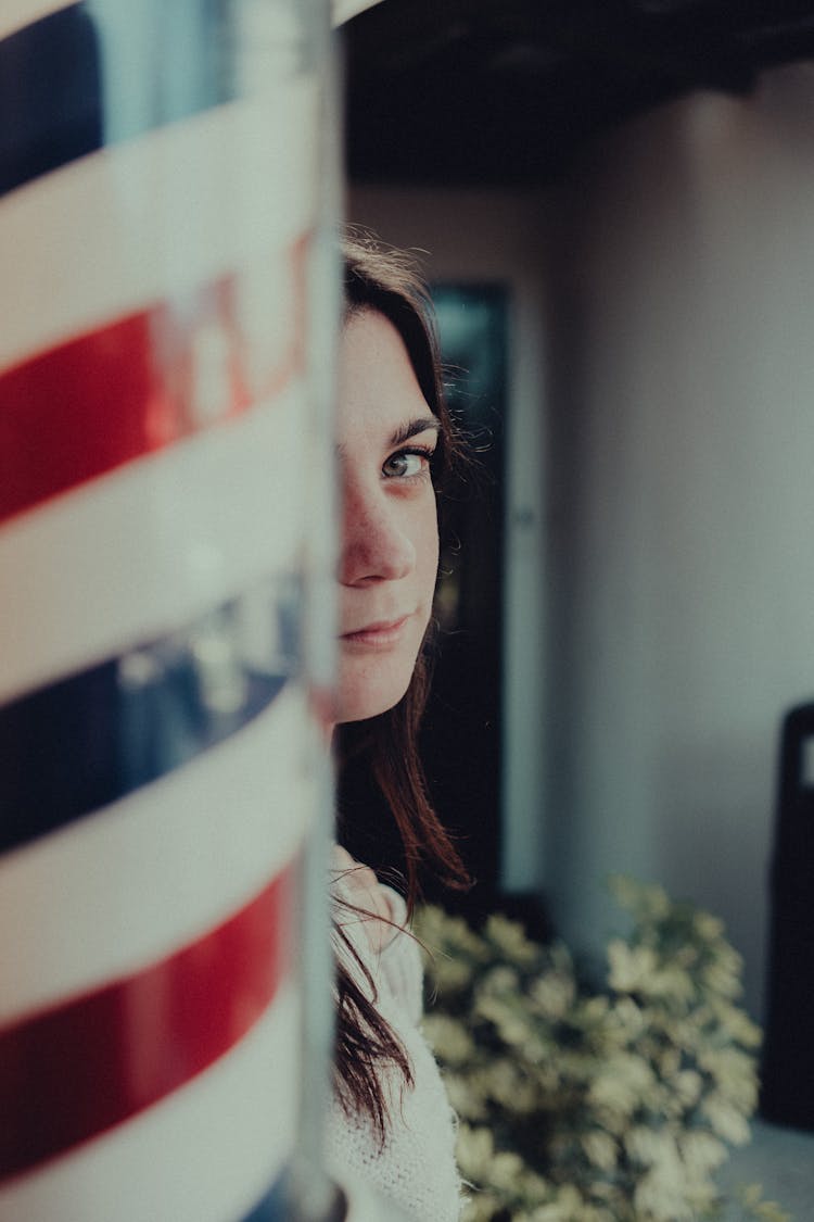 Woman Standing Behind A Barbers Pole Sign 