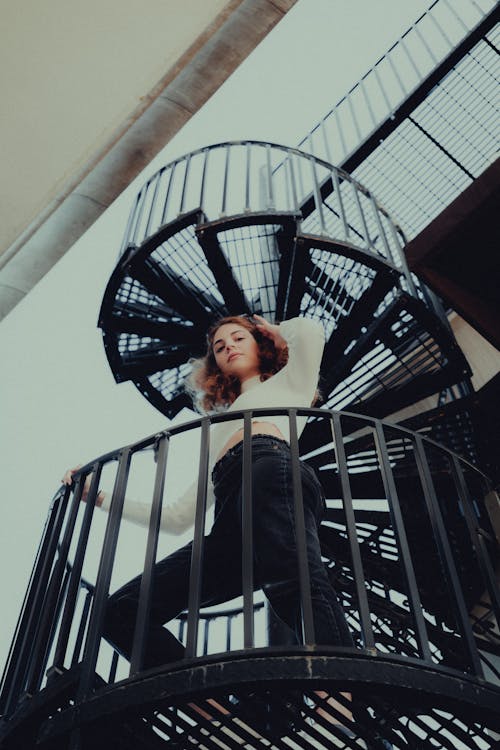 Low Angle Shot of a Woman Standing on a Spiral Staircase 