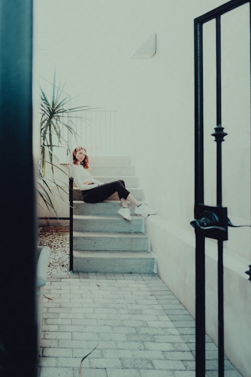 Woman Sitting on Steps in front of a Building 