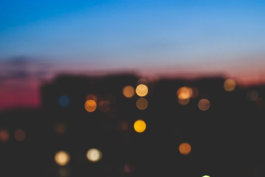 Soft focus city lights against a twilight sky create a dreamy urban atmosphere.