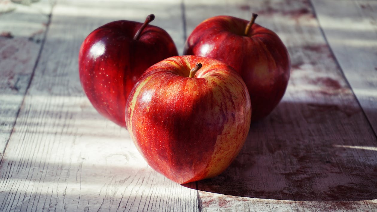Free Three Red Apples on Wooden Surface Stock Photo