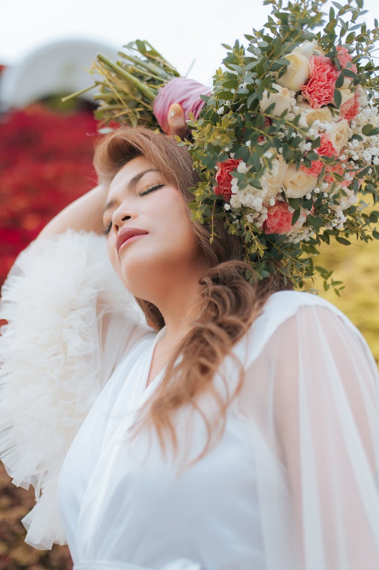 Young Woman With Bouquet In Nature