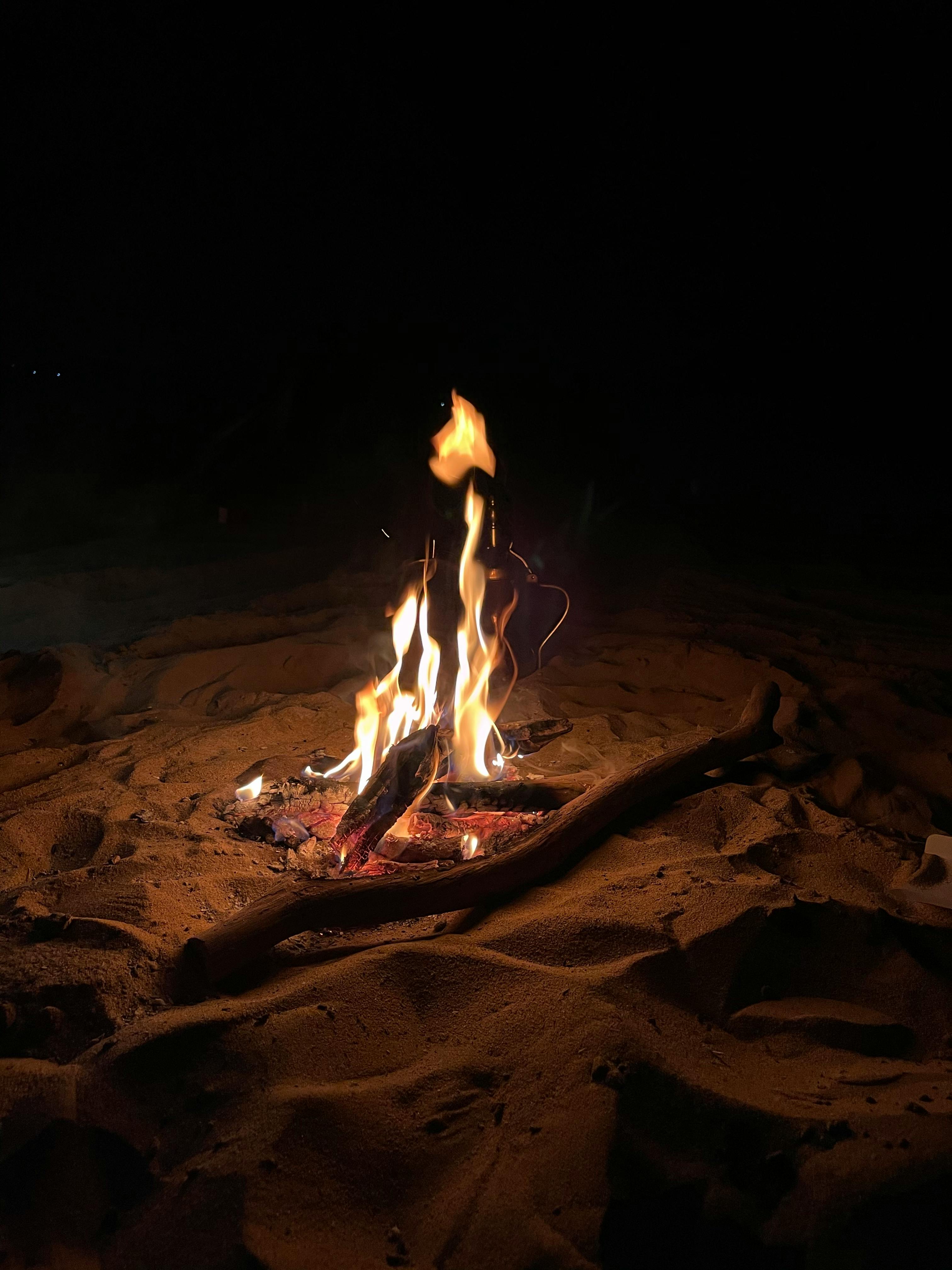 a campfire is lit in the dark