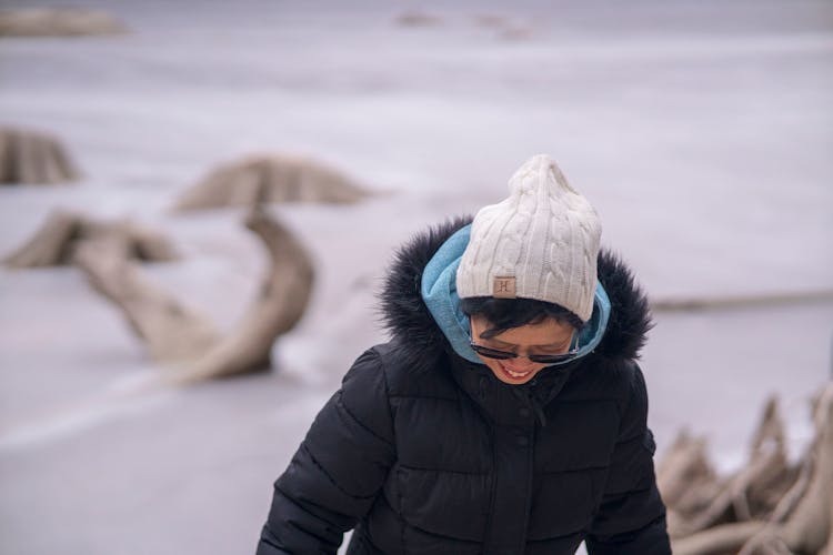 A Woman Wearing A Black Puffer Jacket And A White Bonnet