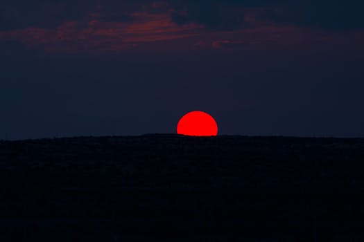 Dramatic red sunset captured over Abu Dhabi's horizon, emphasizing natural beauty.