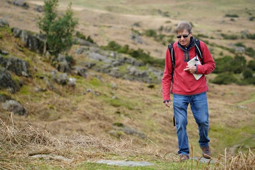 Man Wearing Red Jacket Walking on Pathway