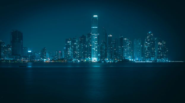 Stunning nighttime view of Panama City's modern illuminated skyline reflecting off the waterfront.