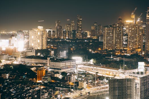 Dynamic aerial view of an illuminated city skyline at night, showcasing a vibrant urban landscape.