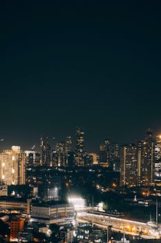 A stunning aerial view of a city skyline at night, showcasing illuminated skyscrapers and vibrant dynamics.