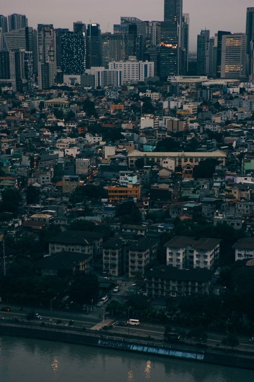 Free A breathtaking aerial view of a bustling city's skyline at dusk, highlighting skyscrapers and dense urban housing. Stock Photo