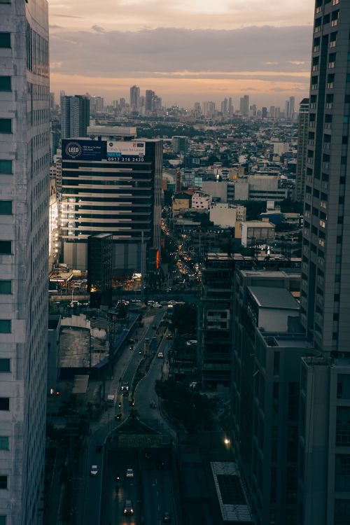 Free Aerial view of a cityscape during dusk with skyscrapers and bustling streets. Stock Photo