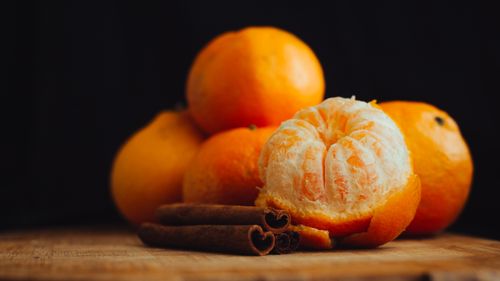 Free A close-up of fresh peeled tangerines with cinnamon sticks, creating a warm, inviting mood. Stock Photo
