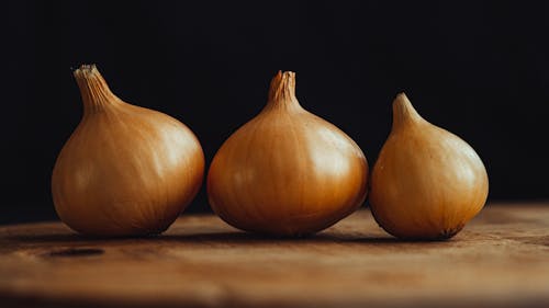 Golden Onions on Wooden Cutting Board