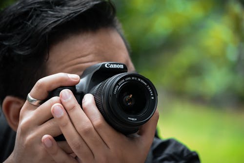 Close Up Photo of Man Using a Black Camera