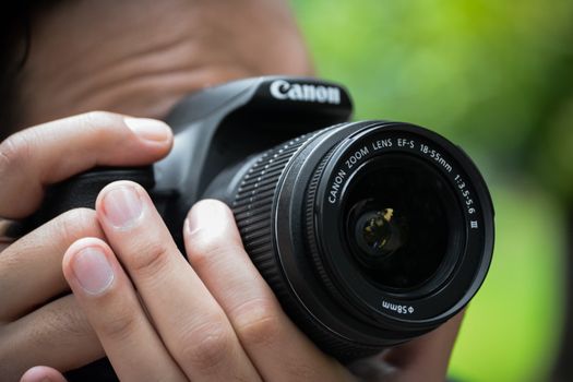 Close-up of hands holding a DSLR camera outdoors in Santiago de Querétaro.