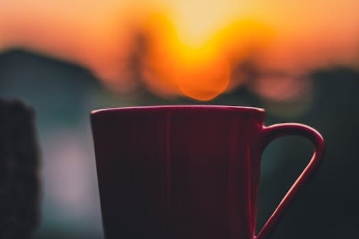 在充满活力的日落背景下，温暖轮廓的咖啡杯营造出平静的氛围