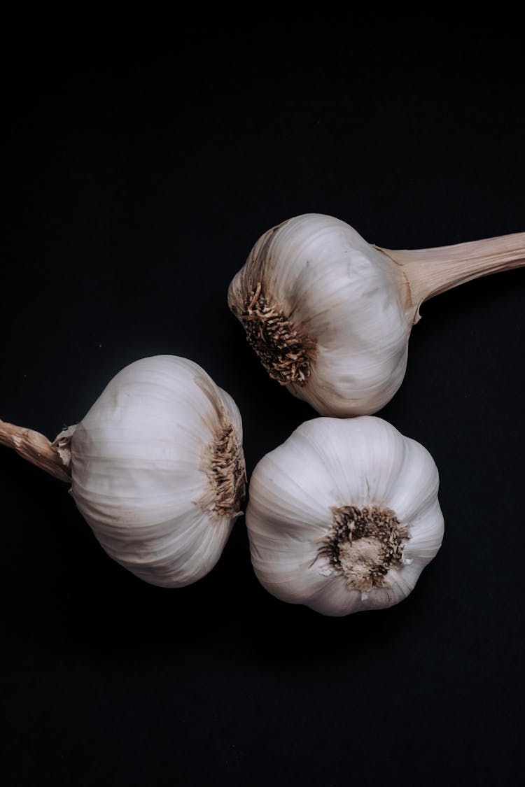 Heads Of Garlic On Black Background