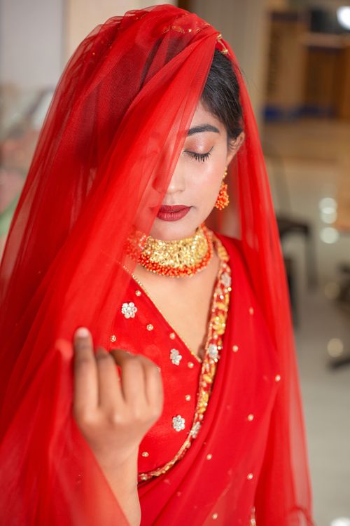 Free A beautiful bride in red traditional attire and veil, captured in Pokhara, Nepal. Stock Photo