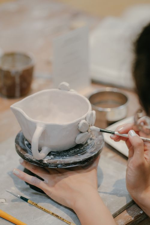 Free Close-up of an artisan skillfully sculpting a handmade ceramic mug in a workshop setting. Stock Photo