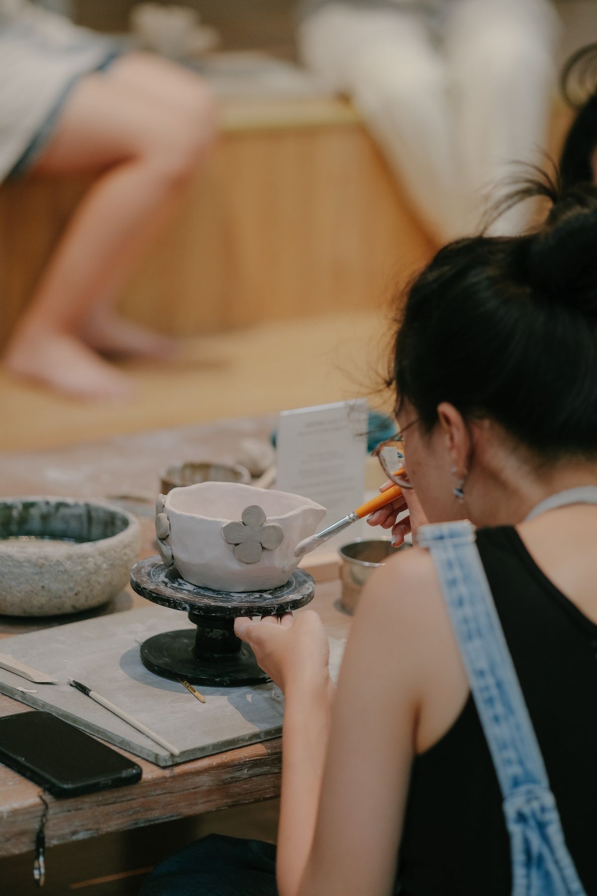 Artisan décorant une pièce de faïence à la main dans un atelier