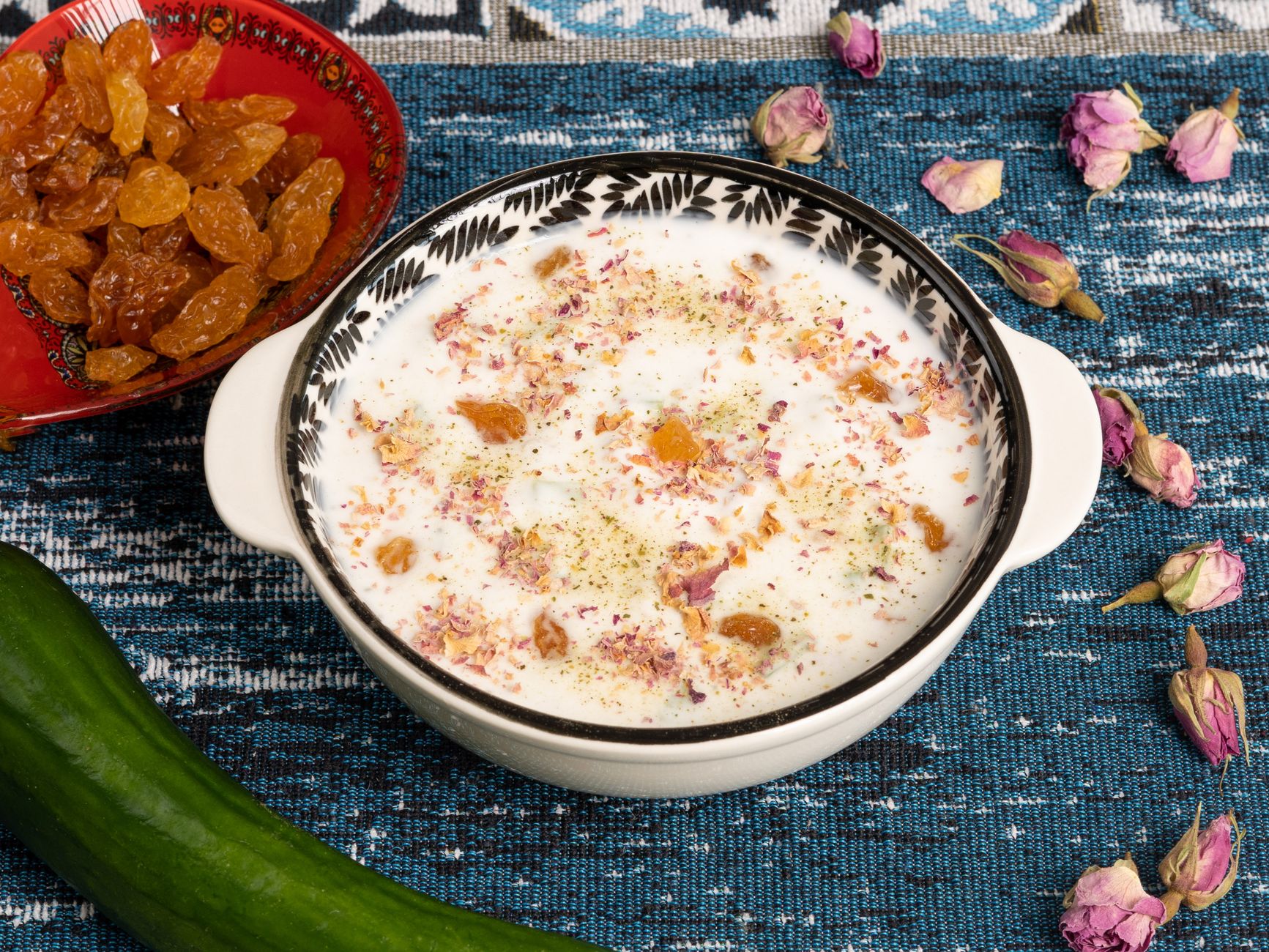 A bowl of steaming hot soup with herbs floating on top