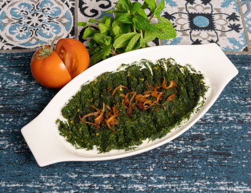 Free A tasty spinach dish garnished with fried onions, served with fresh tomatoes and mint. Stock Photo