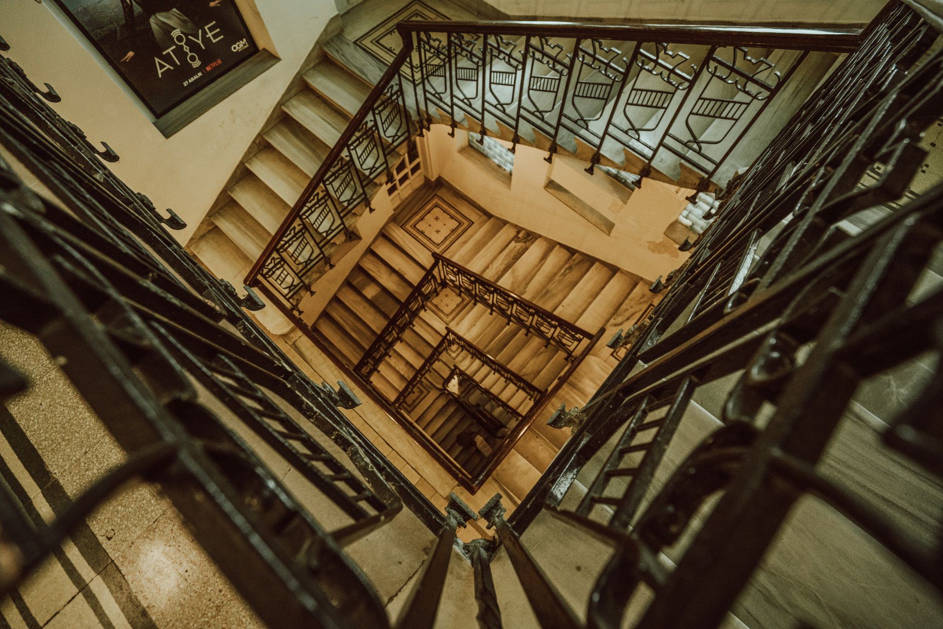 Captivating view of a spiral staircase inside a historic building, showcasing intricate metal railings and classic design.