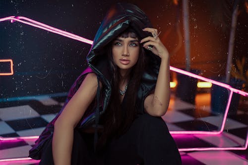 Modern Studio Shot of a Young Woman Wearing a Vest with a Hood 