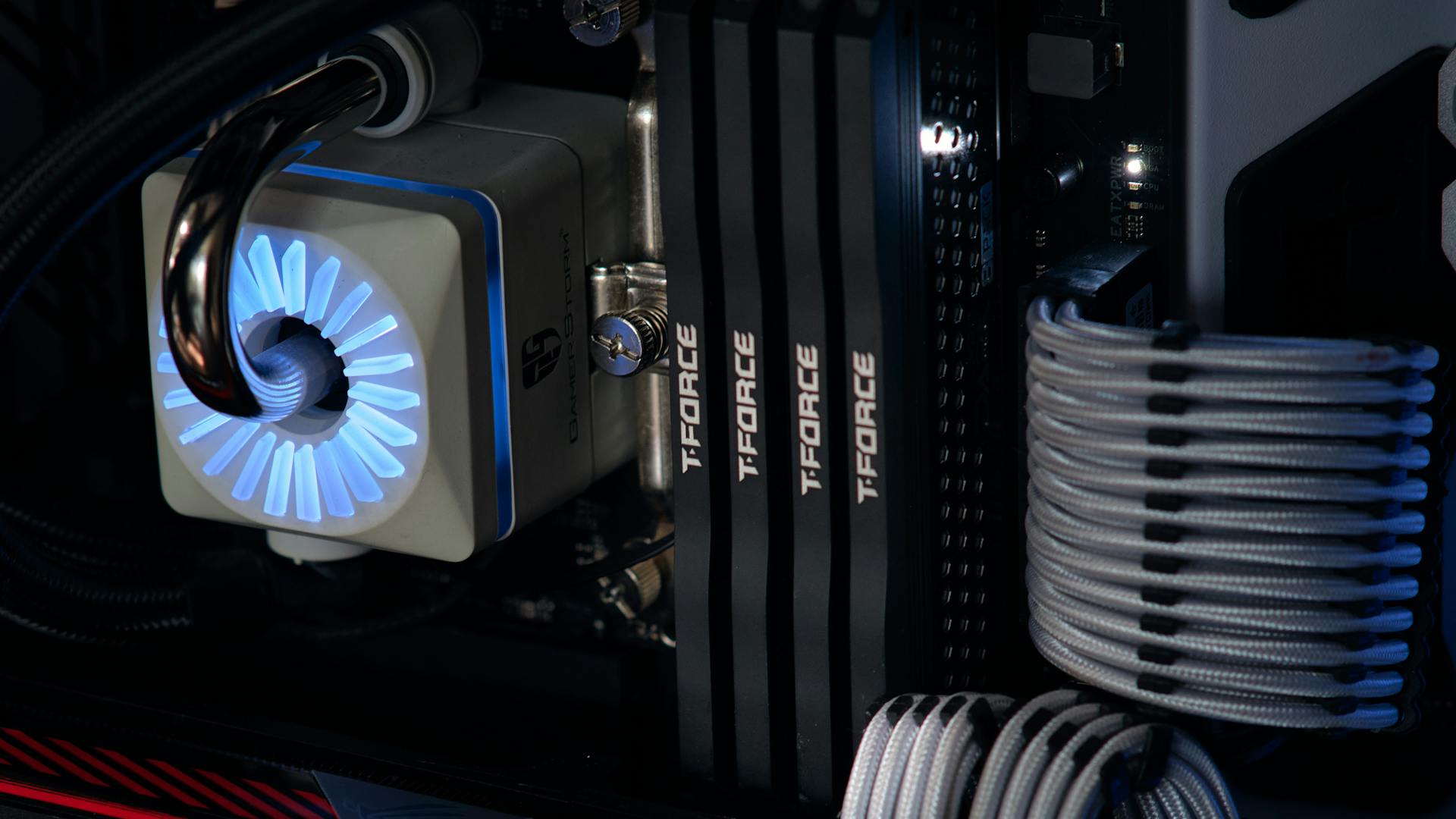 Detailed close-up of a computer cooling system featuring T-FORCE components and blue lighting.