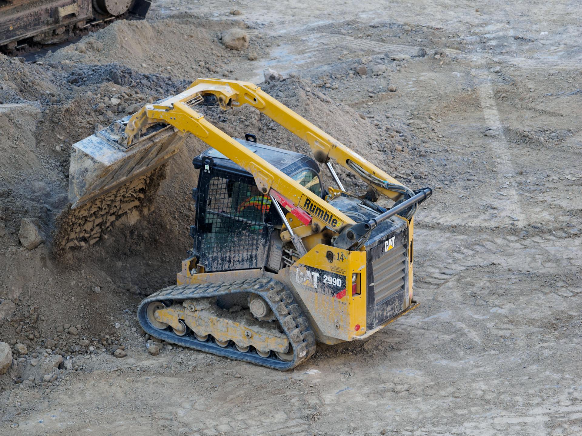 A yellow bulldozer excavates dirt at an industrial construction site, showcasing its powerful machinery.