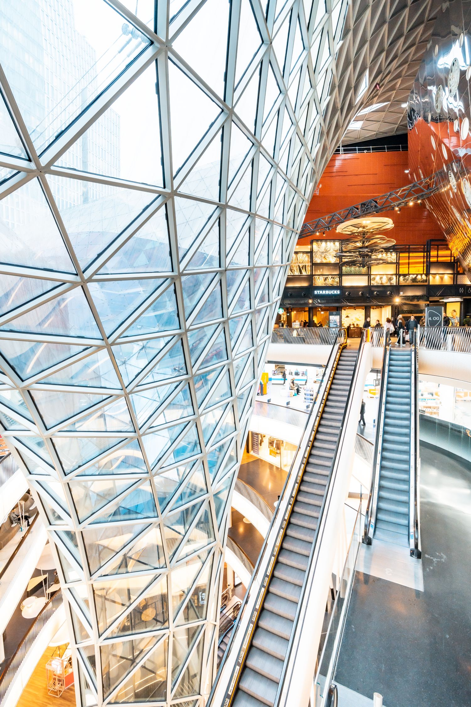 Atrio de centro comercial moderno con luz natural y espacios amplios