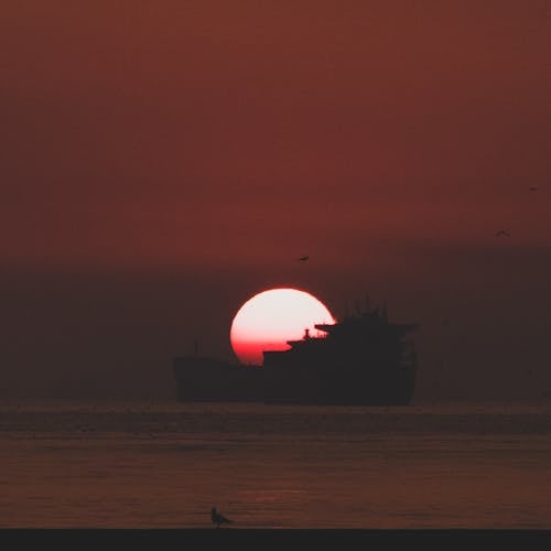 Silhouette of a Ship on the Ocean during Sunset
