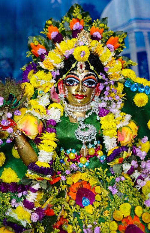 Free Vibrant statue of a Hindu goddess adorned with colorful flowers, symbolizing religious devotion. Stock Photo