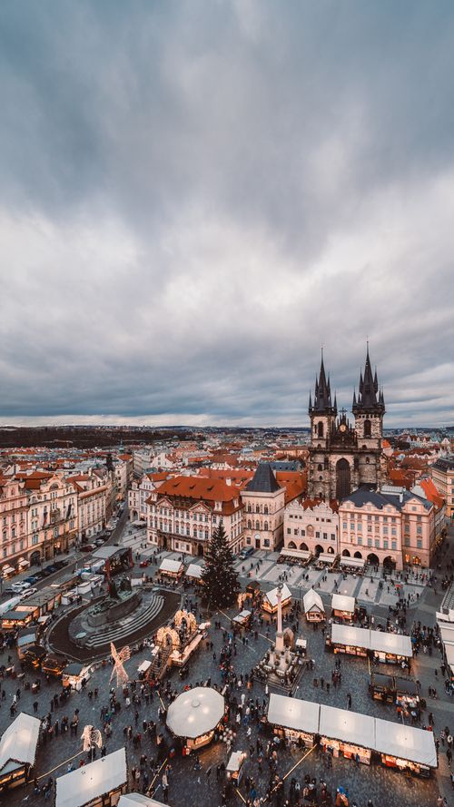 Free Aerial shot of Prague's historic square featuring a bustling market and iconic cathedral. Stock Photo