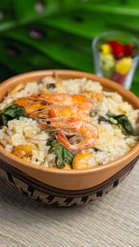 A flavorful bowl of rice with shrimps and greens, perfect for a hearty meal.