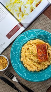 Appetizing risotto with salmon on a vibrant blue plate, perfect dinner setup.