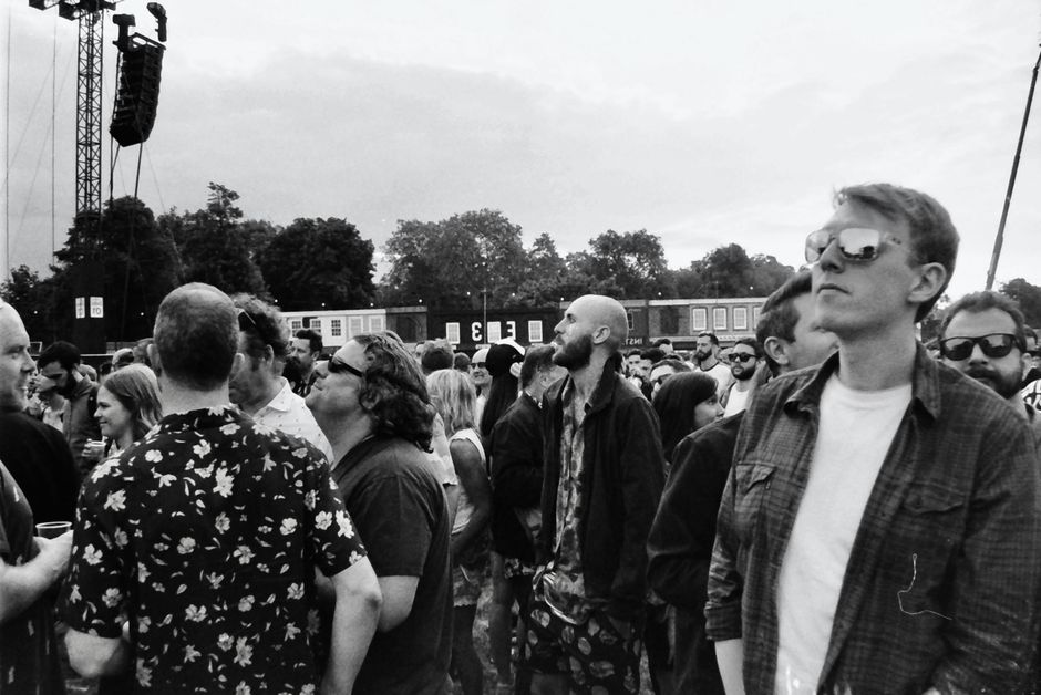 Black and white photo of people enjoying an outdoor music festival in England.