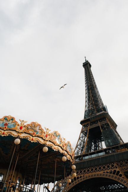 Iconic Eiffel Tower and vintage carousel captured in Paris, a must-visit attraction.